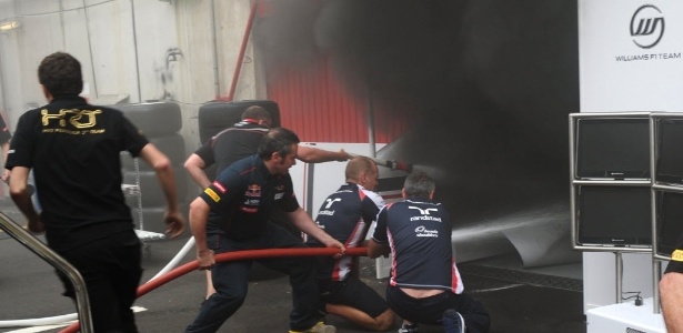 Funcionários das equipes de F-1 tentam apagar o incêndio nos boxes da Williams