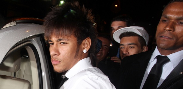 Neymar chega à premiação; ao fundo, de boné, jovem que se envolveu em confusão
