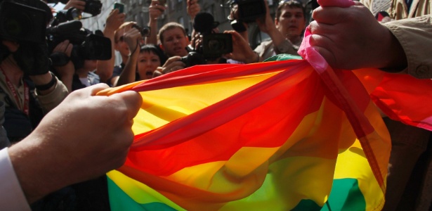 Um homem tenta rasgar a bandeira de  manifestante que participava da Parada Gay de Moscou 
