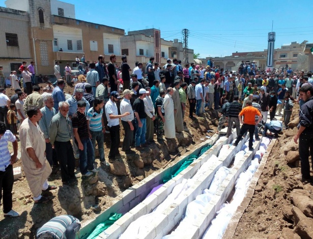 Sírios participam de enterro em massa de vítimas de massacre em Houla, no qual morreram 108 pessoas