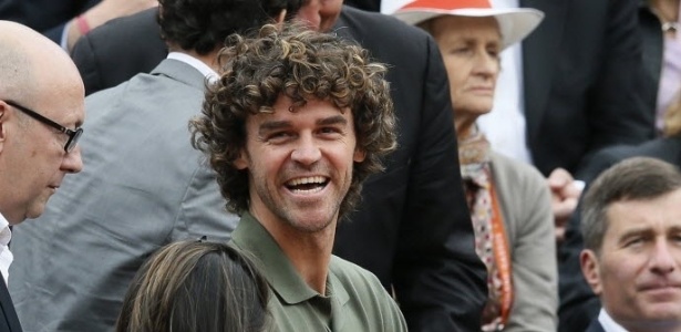 Com a filha no colo, Gustavo Kuerten, o Guga, acompanha jogo em Roland Garros 