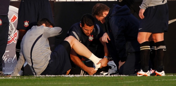 Zagueiro Chicão é atendido pelo médico após torcer o pé durante o treino