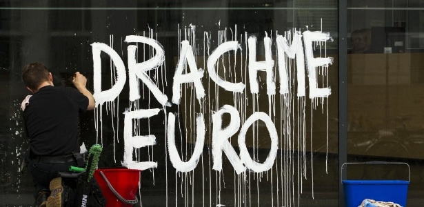Limpador de janela remove grafite de porta de vidro da Academia de Artes de Berlim (Alemanha). Criado pelo grupo de design Bureau Mario Lombardo como contribuição à bienal de arte do país, o grafite "dracma euro" se refere à mistura das moedas da Grécia e da zona do euro