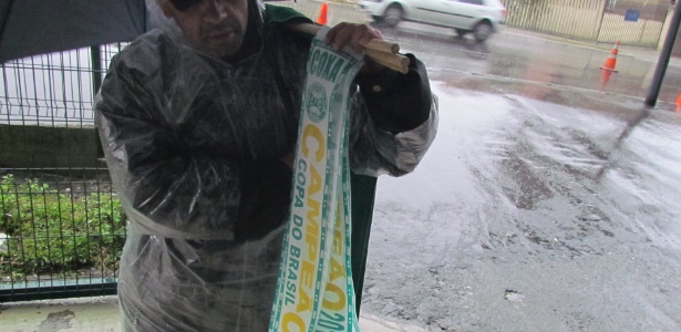 Protegido da chuva, vendedor oferece faixas de campeão do Coritiba