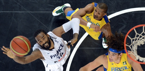 AFP PHOTO / PATRICK HERTZOG Ronny Turiaf, Leandrinho Barbosa e Anderson Varejão disputam a bola no amistoso entre França e Brasil