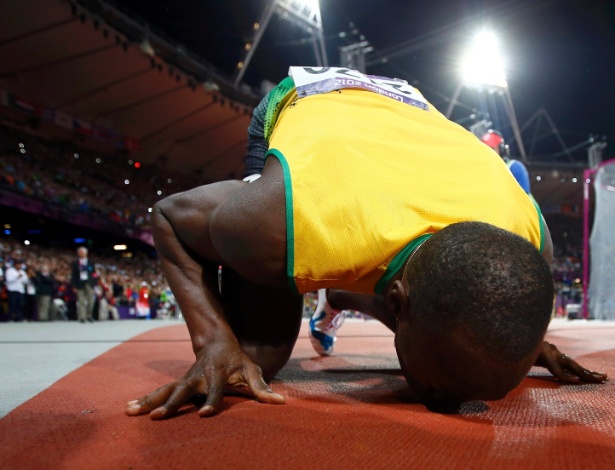 Bolt beija pista do Estádio Olímpico de Londres, após conquistar a medalha de ouro