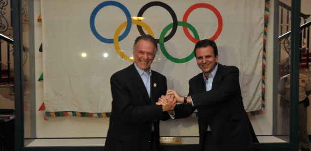 Carlos Arthur Nuzman (e) e Eduardo Pares posam ao lado da bandeira olímpica no Palácio da Cidade