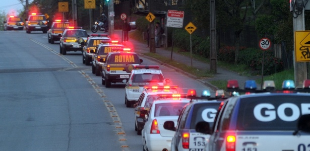Carros de polícia seguem rumo à Vila Sandra, em Curitiba, para ocupação e instalação de UPS