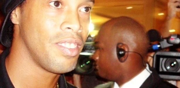 Ronaldinho é cercado por holofotes, câmeras e seguranças em sua chegada ao hotel