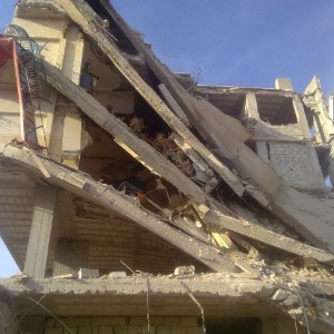 Prédio danificado pelos ataques das forças leais ao presidente Bashar al-Assad, próximo de Damasco