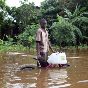 Homem caminha em rua inundada em Ohaute Ducap, no Haiti, por causa do furacão Sandy