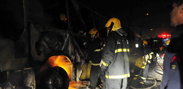 Homens do Corpo de Bombeiros tentam apagar fogo em ônibus que trafegava no bairro dos Ingleses, no norte de Florianópolis (SC)