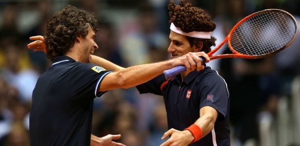 Gustavo Kuerten ri e abraça Novak Djokovic, na imitação de Guga feita pelo sérvio