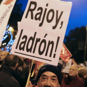 17.dez.2012 - Manifestante segura cartaz em que se lê "Rajoy, ladrão!" durante protesto em Madri, Espanha, nesta segunda-feira. Os manifestantes protestam contra as medidas de austeridade e corte de pensões impostas pelo presidente espanhol Mariano Rajoy para conter a crise política que assola o país