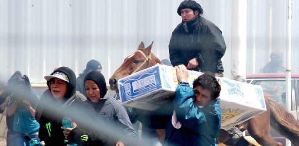 Argentinos correm com mercadorias roubadas de mercado em Bariloche, na Argentina