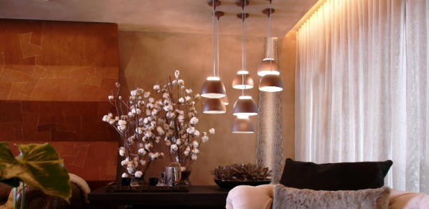 Na sala, a arquiteta Denise Barretto optou por um conjunto de pendentes da Lumini sobre a mesa lateral