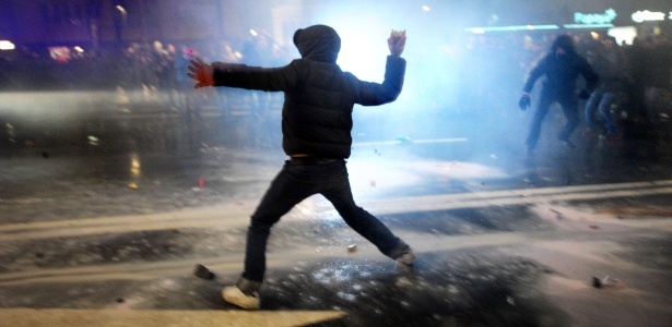 Manifestante joga pedra contra policiais durante protesto contra o governo no centro de Sófia, na Bulgária