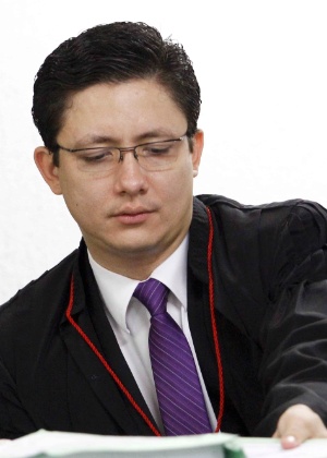 O promotor Henry Castro lê documentos durante julgamento do goleiro Bruno, em Contagem (MG)