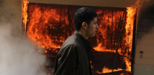 Homem passa em frente a uma delegacia que foi incendiada após o anúncio das condenações