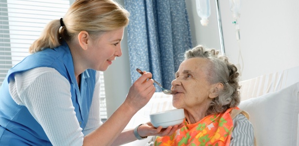 Cuidadora toma conta de idosa com Alzheimer