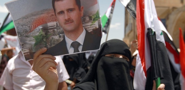 Ativista pró-regime sírio segura cartaz do presidente Bashar Assad em Sanaa, no Iêmen