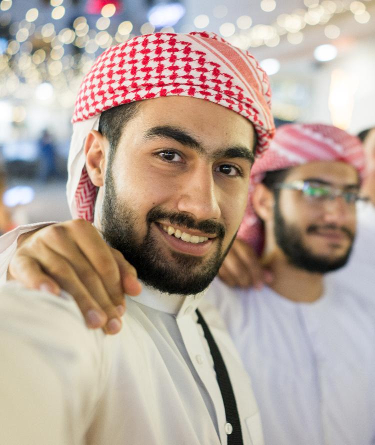 Jovem jordaniano com o keffiyeh em vermelho, a cor mais usada no país