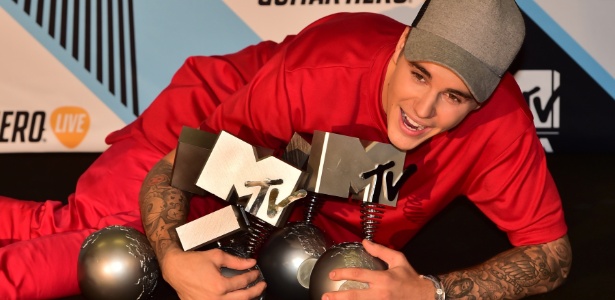 Cantor canadense Justin Bieber posa com todos os troféus conquistados no EMA 2015