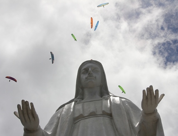 Pilotos de parapente sobrevoam estátua de santa em Governador Valadares durante o Mundial