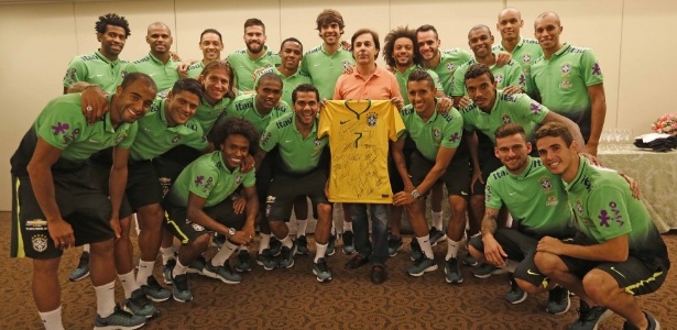 Tom Cavalcante posa com os jogadores e a camisa autografada no hotel, em Fortaleza