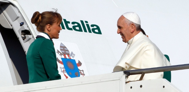 Carregando a sua mala de mão, o papa Francisco embarca no aeroporto de Roma com direção ao Brasil