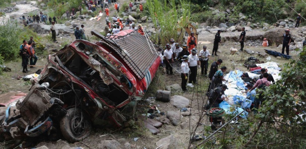 Técnicos forenses trabalham no local onde houve um acidente de ônibus em San Martin Jilotepeque, na região de Chimaltenango, na Guatemala, nesta segunda-feira (9)
