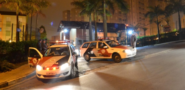 Carros da polícia estacionam fora do condomínio onde família foi encontrada morta em Ferraz de Vasconcelos, na Grande São Paulo.