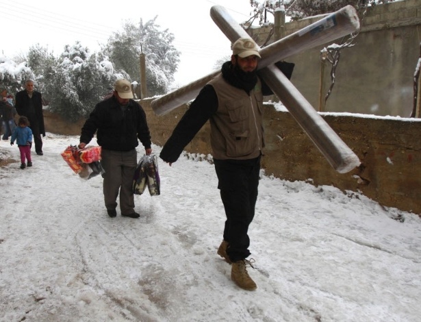 Refugiados sírios caminham na neve em Akroum, no Líbano