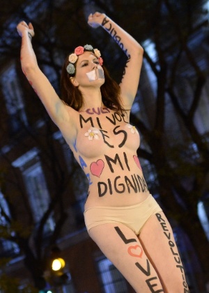 14.dez.2013 - Mulher seminua traz no corpo a frase ''Minha voz é minha dignidade'' durante protesto anticapitalista em Madrid, Espanha. Um grupo de manifestantes cercou o congresso na capital do país