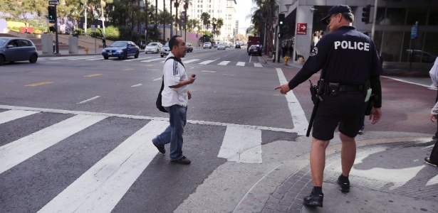 Policial multa pedestre por atravessar a rua ilegalmente no centro de Los Angeles (EUA)