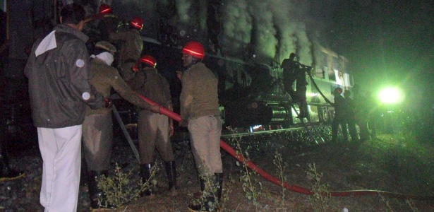 Bombeiros tentam conter incêndio em trem em ferrovia perto de Puttapartihi (Índia)