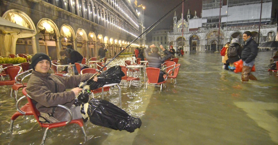  - 1fev2014---jovem-finge-pescar-na-praca-sao-marcos-em-veneza-na-italia-a-cidade-sofre-com-enchentes-nesta-epoca-do-ano-com-as-aguas-subindo-140-cm-acima-do-normal-1391253371298_956x500