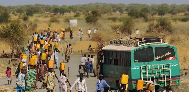Pessoas deslocadas internamente (PDIs) carregam água enquanto caminham em direção à entrada de uma missão das Nações Unidas na República do Sudão do Sul (UNMISS), com base em Malakal, nesta quinta-feira (6). Em seus combates recentes, o país tem visto ondas de ataques de vingança brutal, como lutadores e milícia étnica usando a violência para saquear e acertar velhas contas. As Nações Unidas e os ativistas de direitos humanos têm relatado que atrocidades horríveis foram cometidas por ambos os lados
