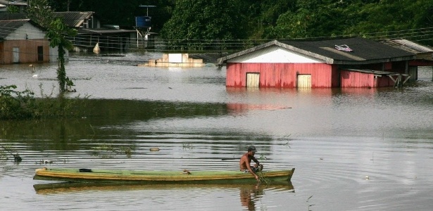 Morador de Rio Branco (AC) usa barco para atravessar região alagada da cidade. Com as fortes chuvas da última semana, o rio Acre continua a subir, inundando áreas do Estado brasileiro, do norte da Bolívia e do leste do Peru
