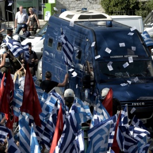 Apoiadores do partido ultranacionalista grego Aurora Dourada saúdam a chegada, em uma van da polícia, do líder preso Nikos Michaloliakos à Corte de Apelações de Atenas, em julho deste ano