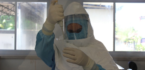 Cientista usa roupas impermeáveis e equipamentos de proteção individual indicados para análise de vírus altamente contagiosos no Instituto Evandro Chagas, em Belém