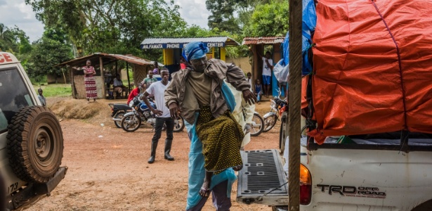 Enfermeiro carrega paciente com suspeita de ter contraído ebola em Kakata, na Libéria