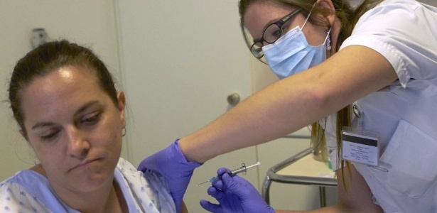 4.nov.2014 - Enfermeira aplica vacina experimental contra o vírus ebola em voluntária, no hospital universitário de Lausanne, na Suíça. 120 voluntários saudáveis estão testando a vacina da GlaxoSmithKline