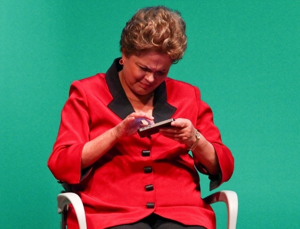 A presidente Dilma Rousseff mexe no telefone do ministro Afif Domingos (Micro e Pequena Empresa), durante evento em 2014