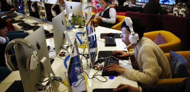 Jovem usa computador em cibercafé de Pequim