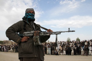 Integrante do grupo Taleban aguarda execução de três homens na província de Ghazni, no Afeganistão
