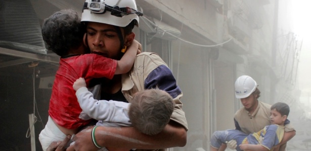 Sultan Kitaz/ Reuters Membros da Defesa Civil socorrem crianças após ataque em Aleppo