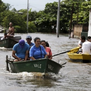 Pessoas usam barco para transitar em rua alagada de Assunção, no Paraguai, em dezembro