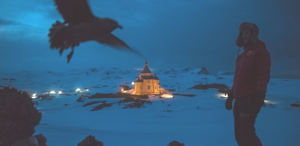 Cientista caminha com a igreja ortodoxa russa ao fundo, em área de bases da Antártida