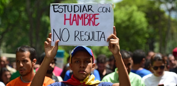26.mai.2016 - Venezuelano protesta contra Nicolás Maduro com cartaz: "estudar com fome não dá resultado"